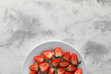 Photo of Food photography. Plate of delicious ripe strawberries on grey textured table, top view with space for text