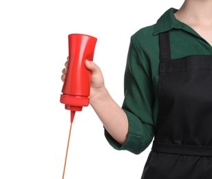 Photo of Woman pouring tasty ketchup from bottle on white background, closeup