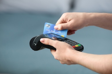 Woman using modern payment terminal indoors, closeup