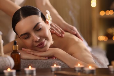 Photo of Spa therapy. Beautiful young woman lying on table during massage in salon