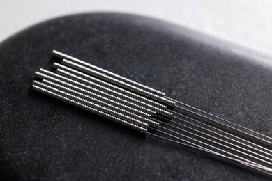 Photo of Acupuncture needles on spa stone, closeup view