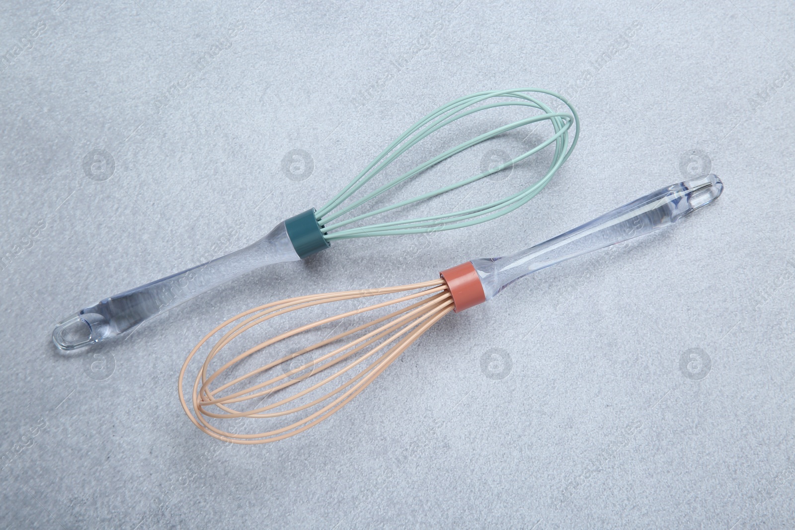 Photo of Two whisks on gray table, top view