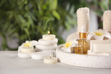 Photo of Beautiful composition with aroma oil and spa stones on table. Space for text