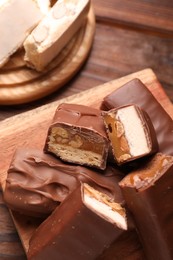 Photo of Tasty chocolate bars with nougat on table, closeup