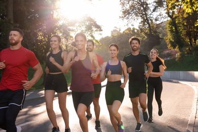 Photo of Group of people running outdoors on sunny day