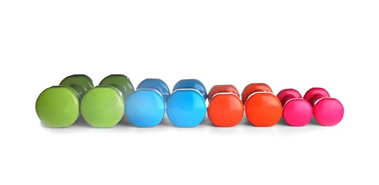Photo of Many colorful dumbbells on white background. Fitness equipment
