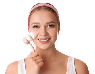 Photo of Young woman washing face with brush and cleansing foam on white background. Cosmetic products