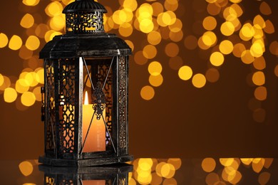 Photo of Arabic lantern on mirror surface against blurred lights, space for text