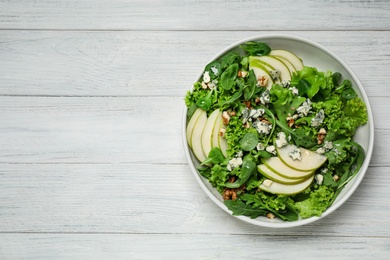 Photo of Fresh salad with pear on white wooden table, top view. Space for text