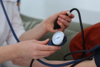 Photo of Doctor checking blood pressure of man in clinic, closeup
