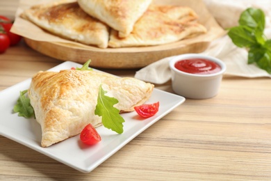 Photo of Fresh delicious puff pastry served on wooden table