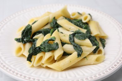Photo of Tasty pasta with spinach and sauce on white table, closeup