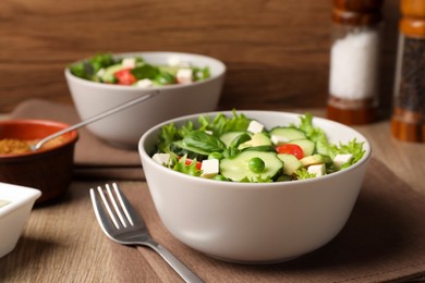 Photo of Tasty fresh salad with cucumber served on wooden table