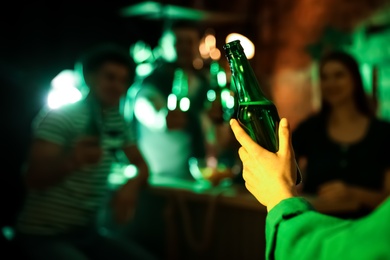 Woman with beer celebrating St Patrick's day in pub, closeup