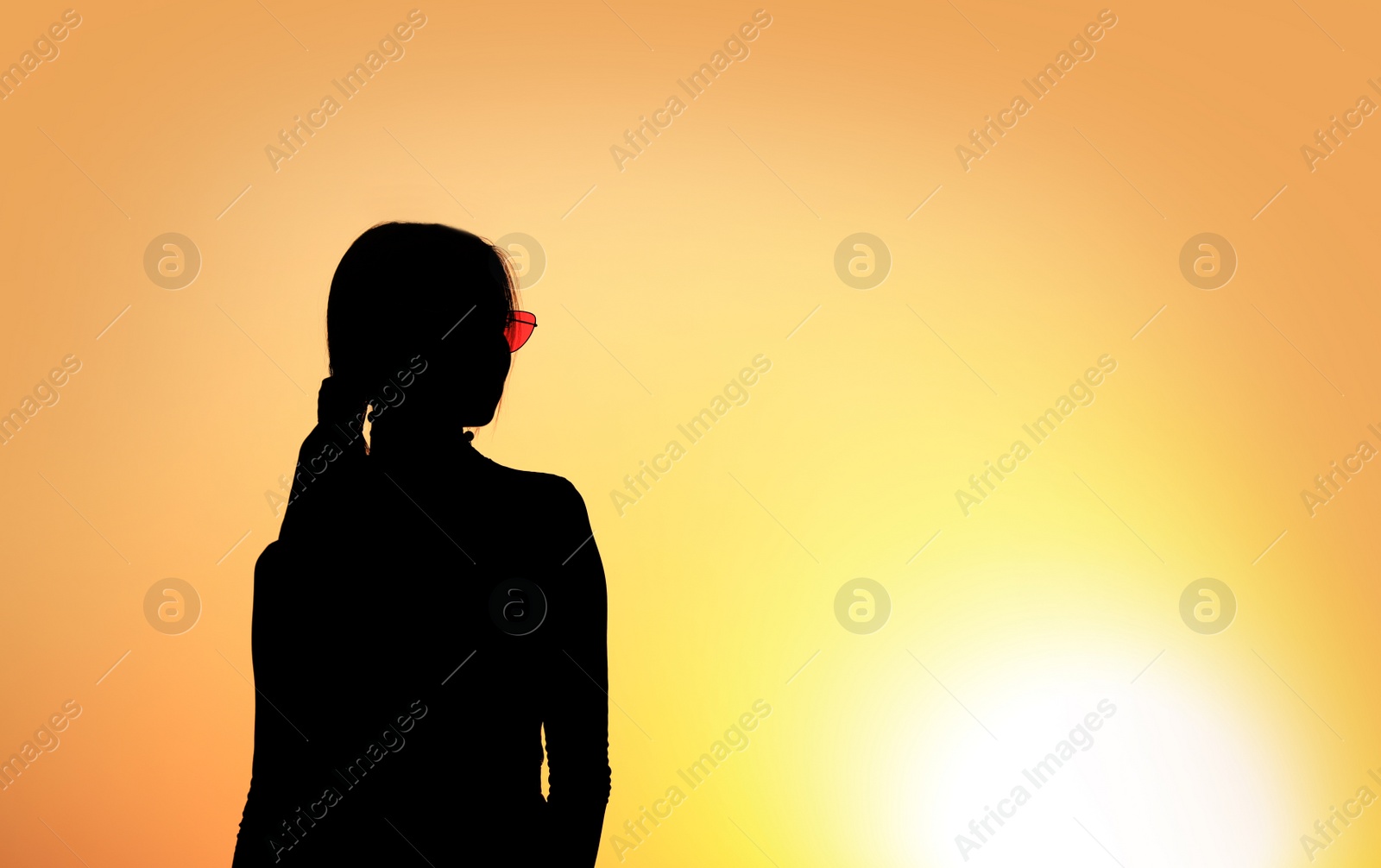 Photo of Silhouette of young woman outdoors at sunset