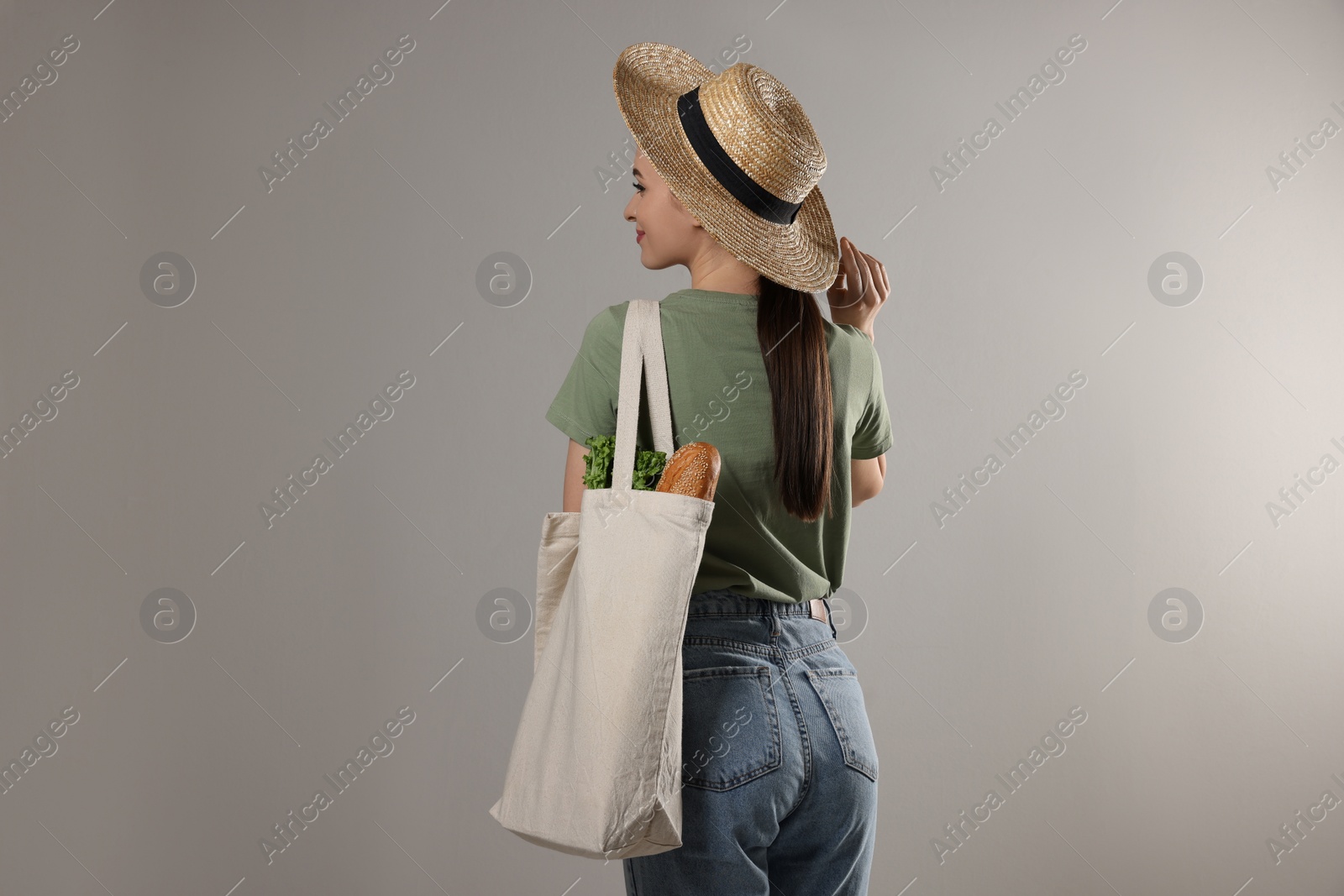 Photo of Woman with eco bag full of products on light background