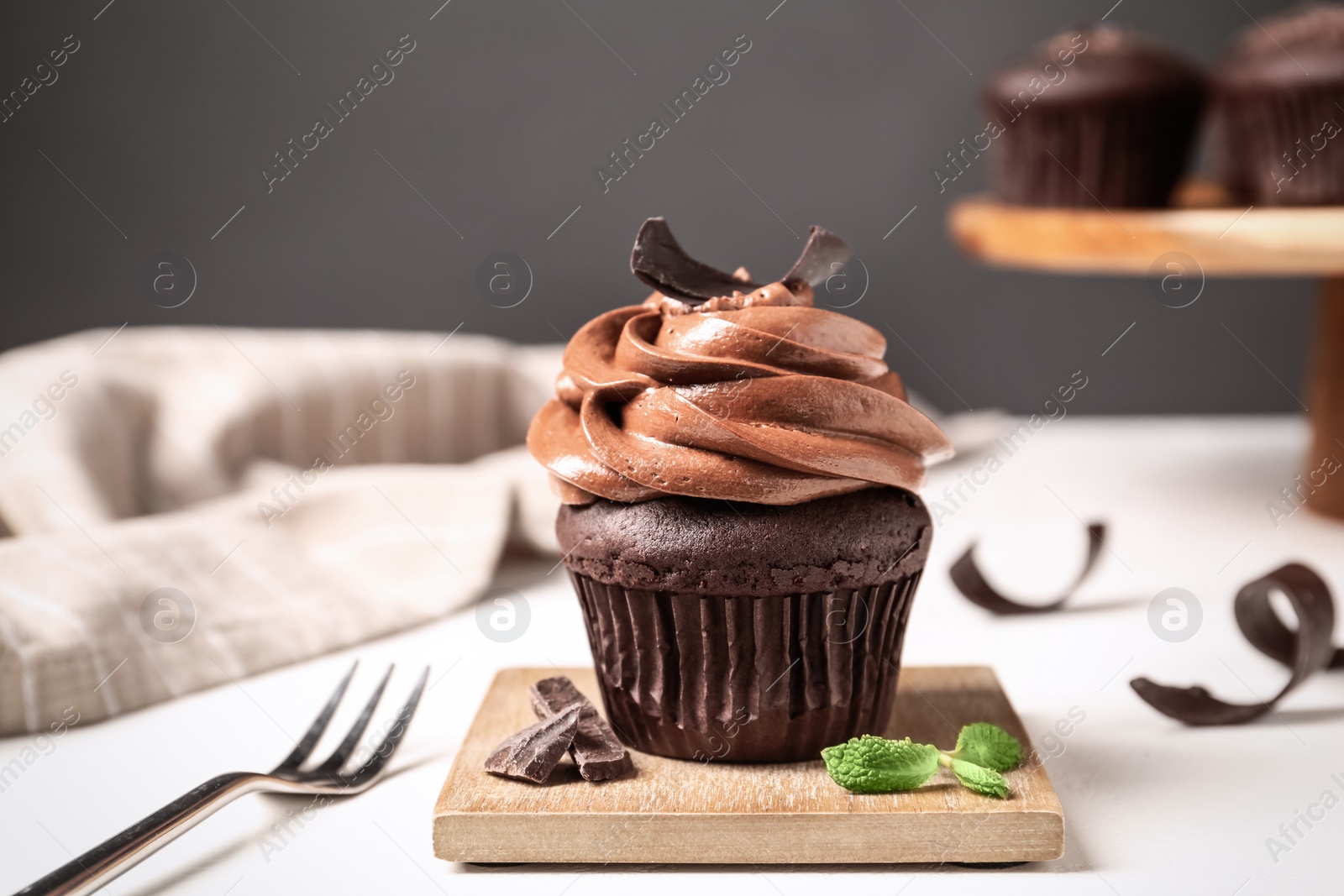 Photo of Delicious cupcake decorated with cream served on white table