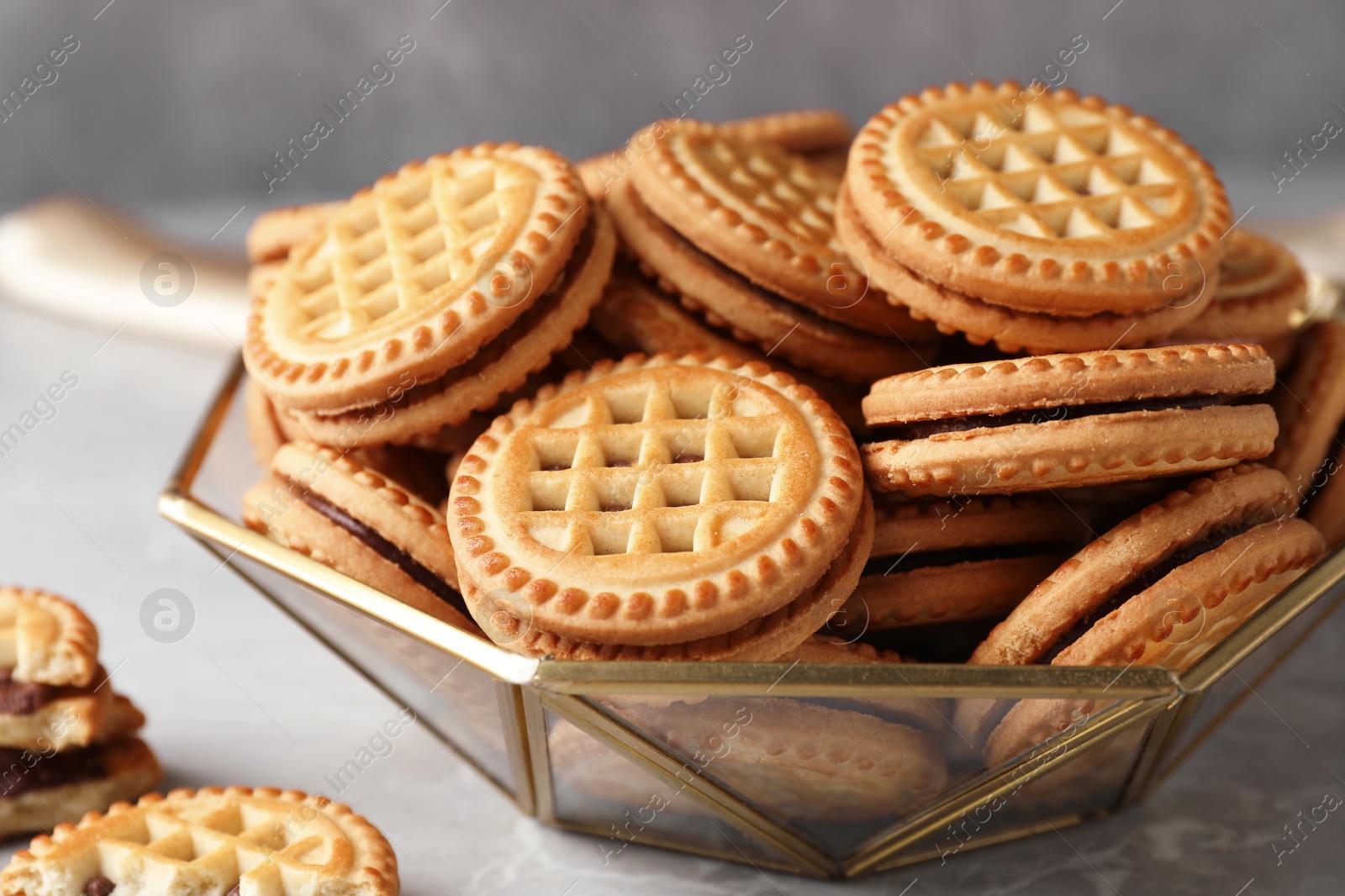 Photo of Tasty sandwich cookies with cream on grey table, closeup