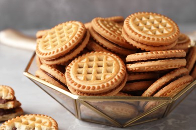 Photo of Tasty sandwich cookies with cream on grey table, closeup