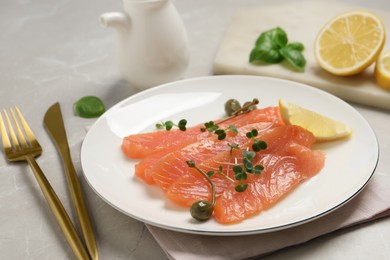 Photo of Delicious salmon carpaccio served on light grey table, closeup