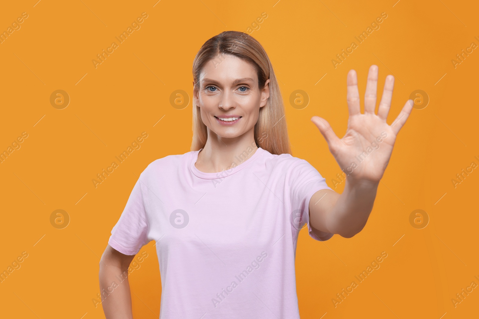 Photo of Woman giving high five on orange background