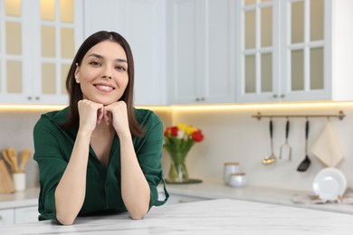Portrait of beautiful young woman in kitchen
