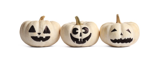 Photo of Halloween pumpkins with cute drawn faces on white background