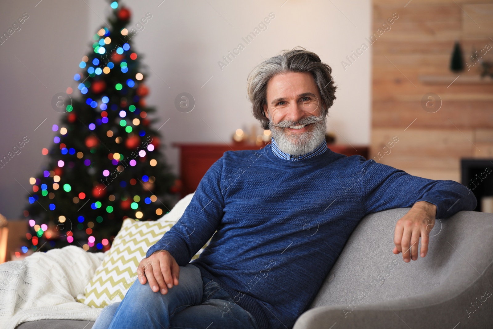 Photo of Mature man on sofa at home. Christmas eve