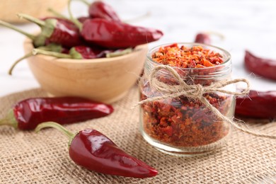 Photo of Chili pepper flakes and pods on table