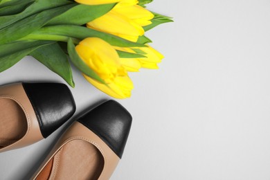 Photo of Pairnew stylish square toe ballet flats and beautiful tulips on light grey background, flat lay. Space for text