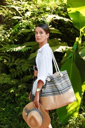 Photo of Beautiful young woman walking in green tropical park