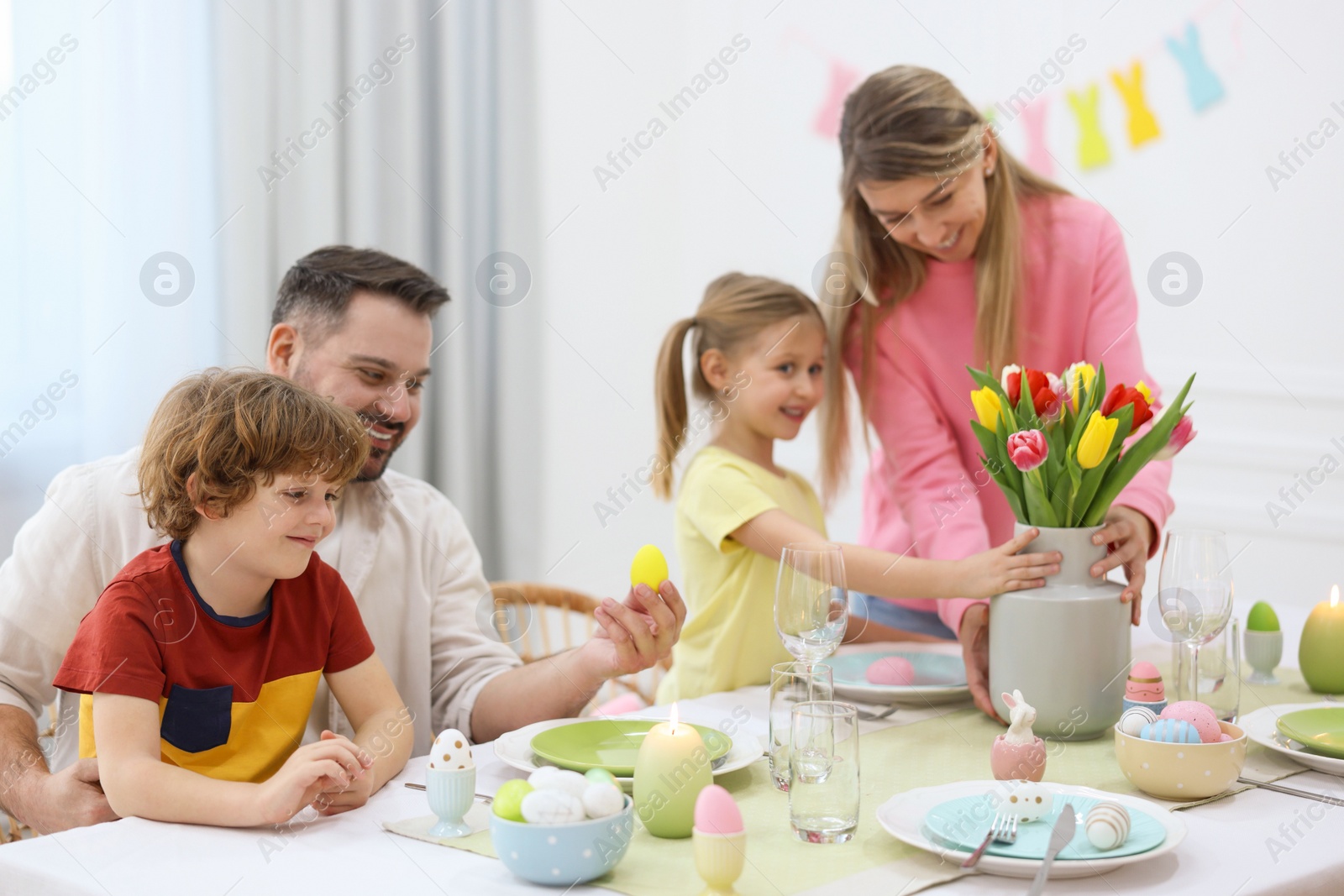 Photo of Easter celebration. Happy family setting table at home