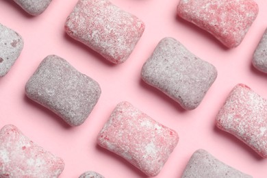 Photo of Tasty colorful bubble gums on pink background, flat lay