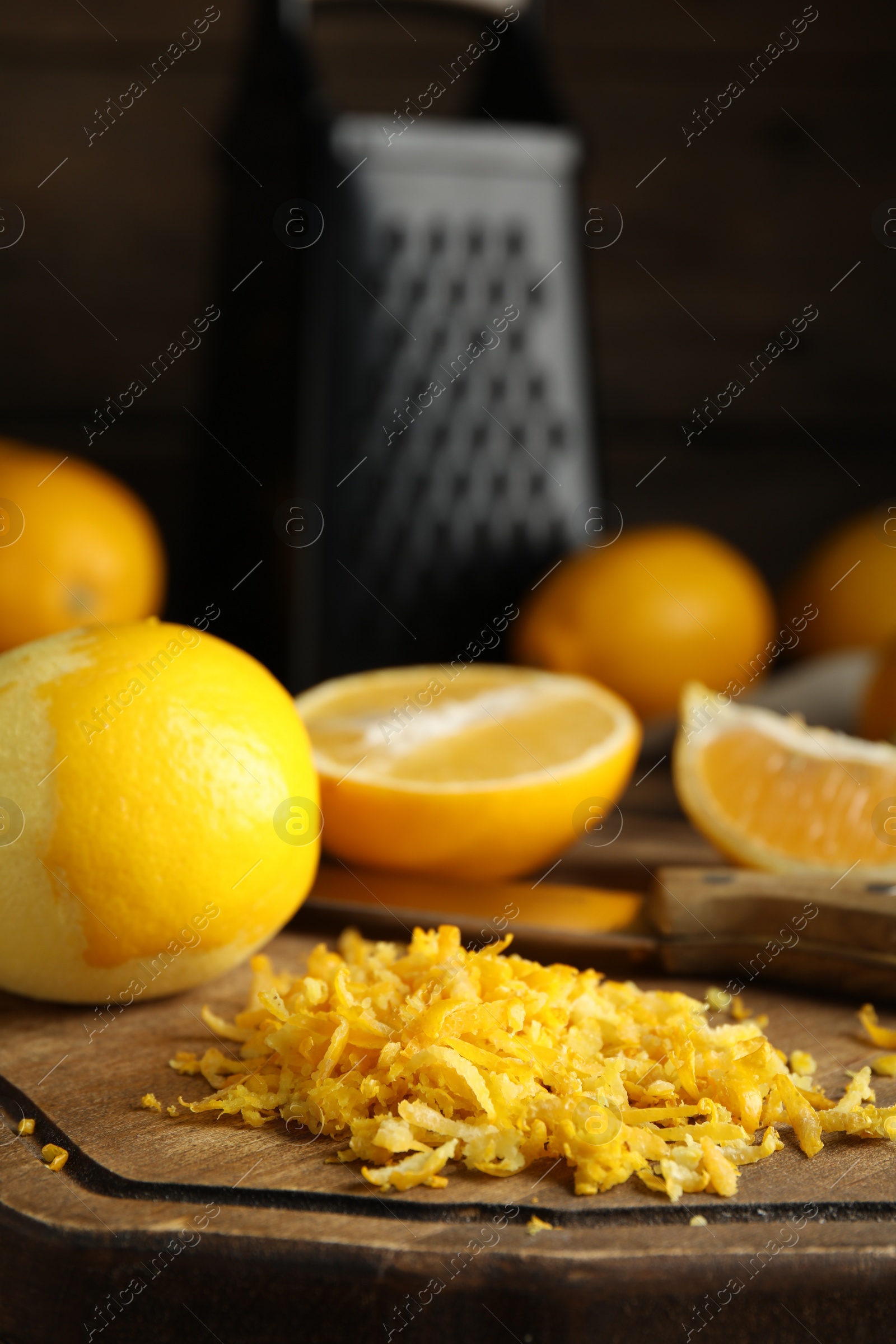 Photo of Lemon zest and fresh fruits on wooden board, closeup