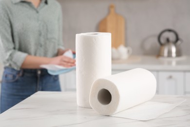 Photo of Woman wiping plate with paper towel in kitchen, selective focus
