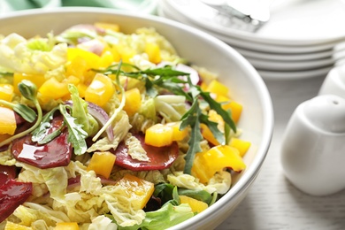 Photo of Bowl with tasty beets salad on table, closeup