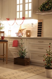 Small Christmas trees and festive decor in kitchen