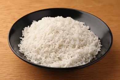 Photo of Plate with delicious rice on wooden table, closeup