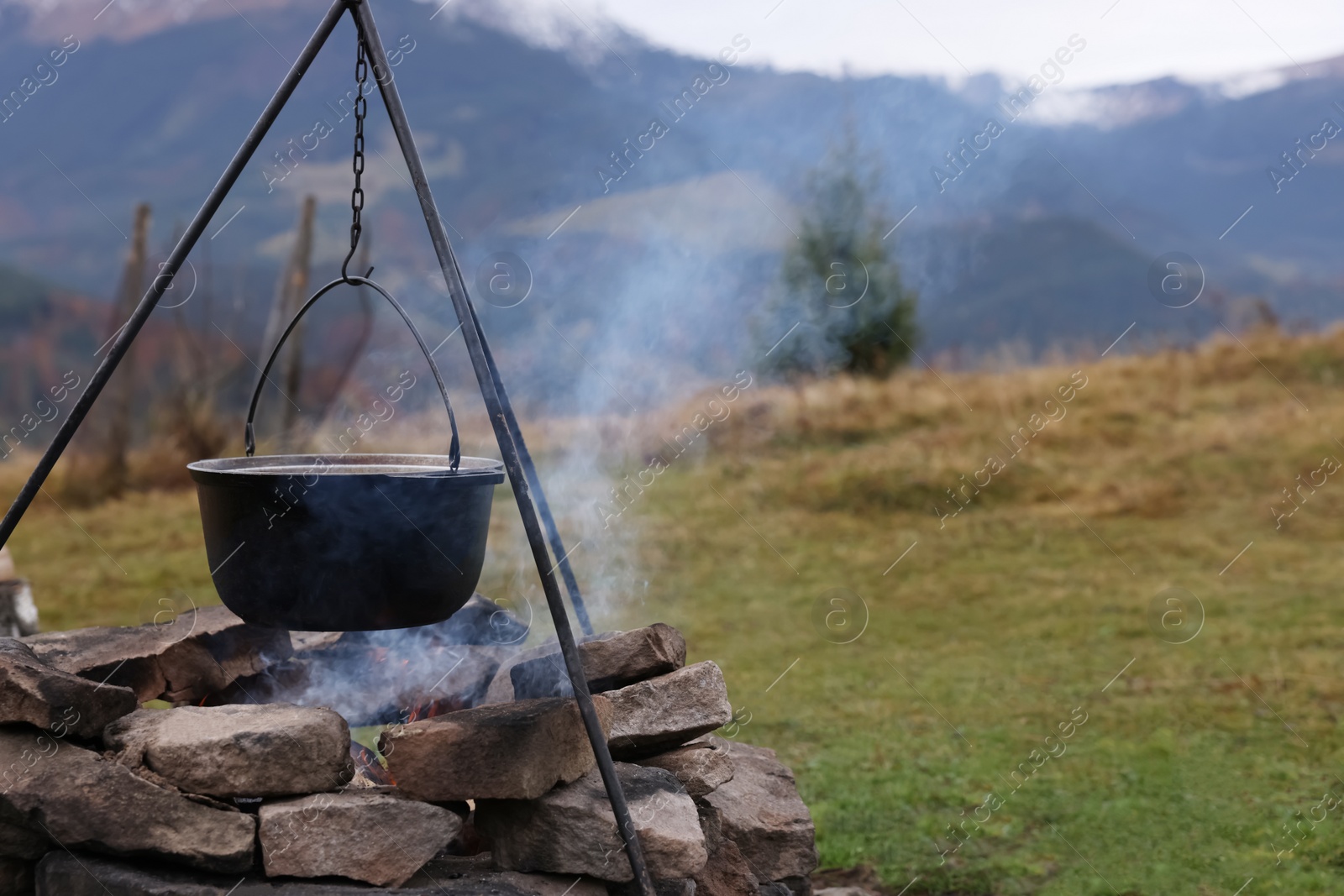 Photo of Cooking food on campfire in mountains. Camping season