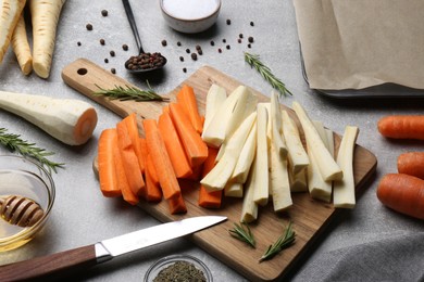 Photo of Composition with parsnips, carrots and other products on light grey table