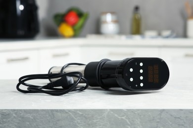 Photo of Thermal immersion circulator on table in kitchen. Sous vide cooking