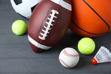 Set of different sport balls and shuttlecock on grey wooden table