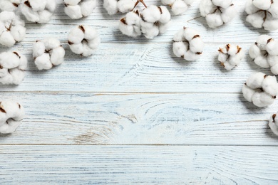 Photo of Flat lay composition with cotton flowers on white wooden background. Space for text