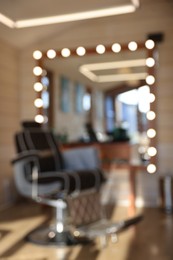 Photo of Blurred viewstylish barbershop interior with hairdresser workplace