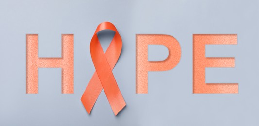 Orange awareness ribbon and word HOPE on light grey background, top view. Banner design