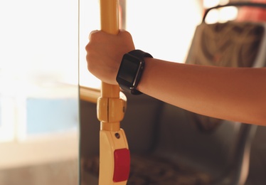 Young woman with smart watch in bus, closeup