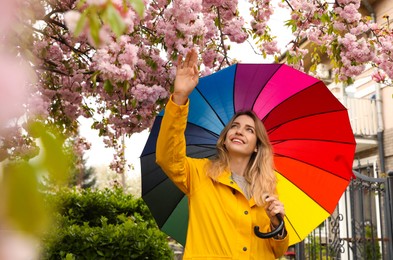 Young woman with umbrella in park on spring day