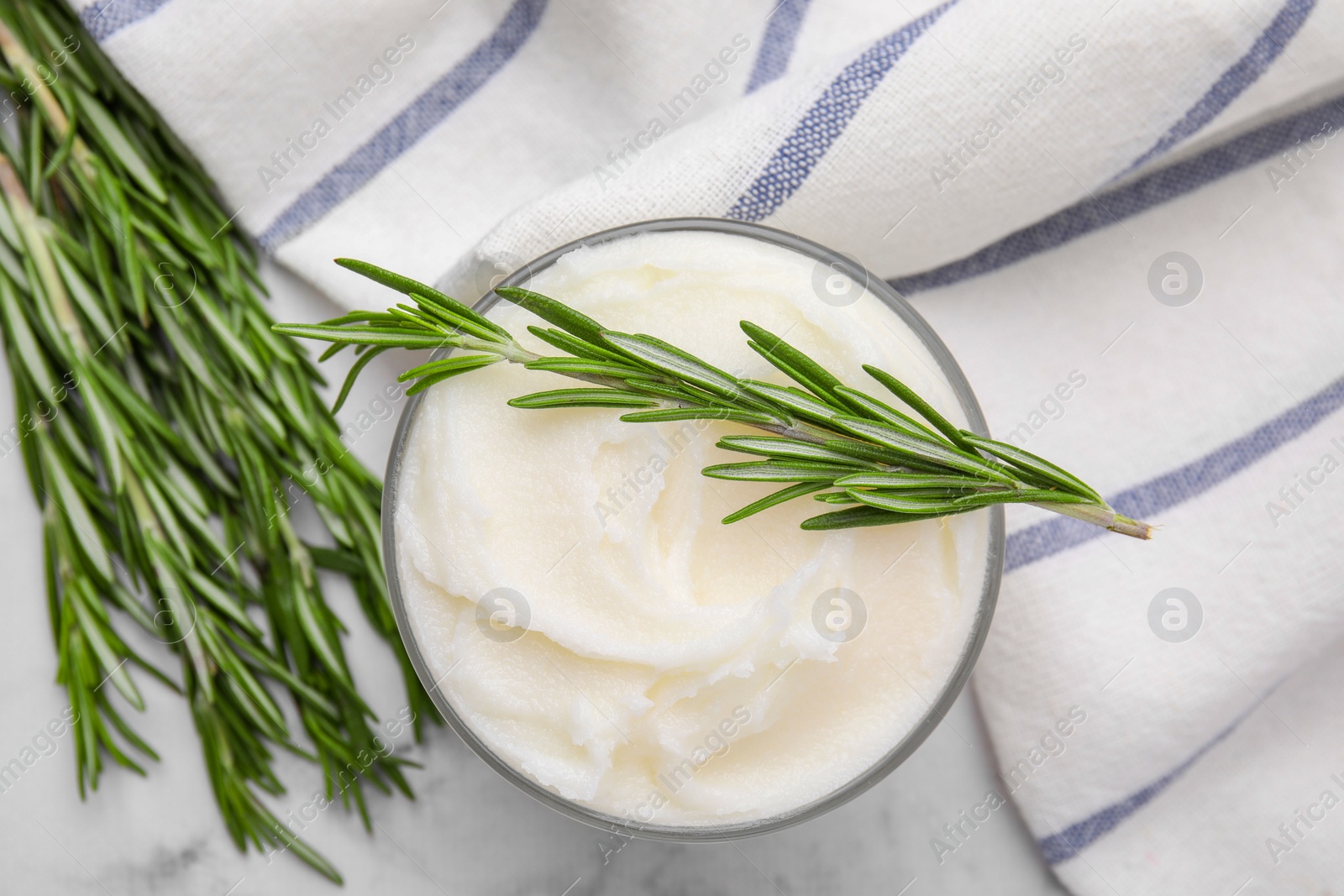 Photo of Delicious pork lard with rosemary in glass on white marble table, flat lay