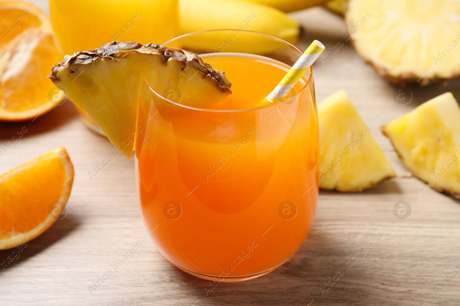 Photo of Tasty juice in glass on wooden table, closeup