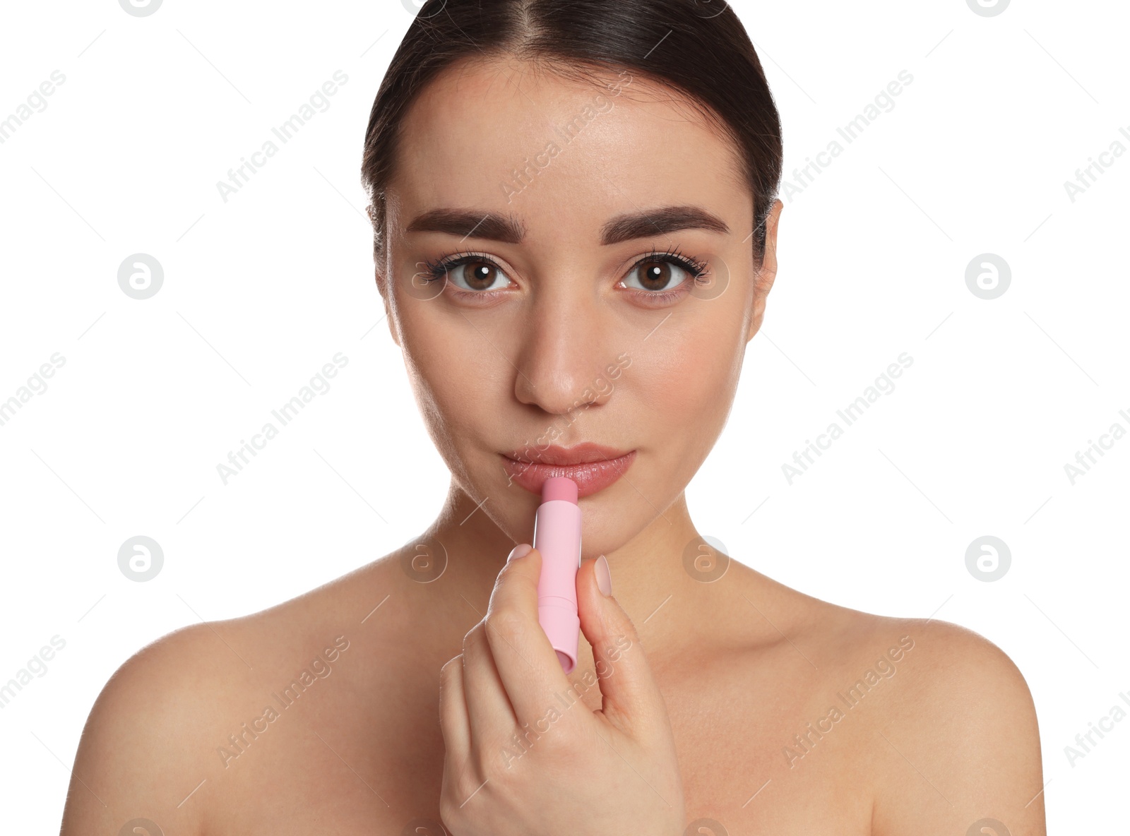 Photo of Young woman applying lip balm on white background